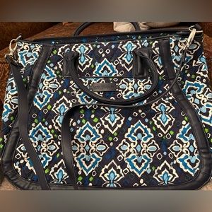 Vera Bradley trapeze tote with top handles and crossbody strap.
